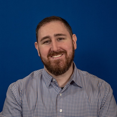 a white man with short brown hair and beard.