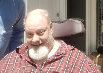 photo of Brad sitting in a chair wearing a red plaid shirt