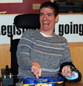Cody smiles widely in a direction slightly to the left of the camera.